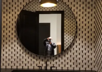 A bathroom with black and white polka dot walls and a mirror.