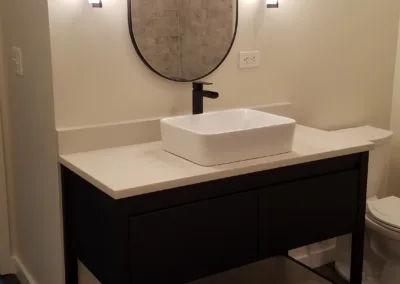 A bathroom with a sink, toilet and mirror.