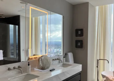 A bathroom with two sinks and a large mirror.