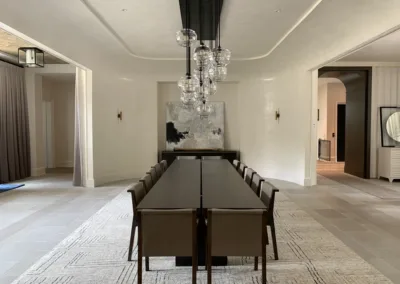 A dining room with a large table and chairs.