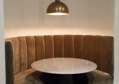 A dining room with a round table and chairs.