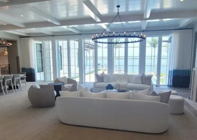 A large living room with white furniture and a fireplace.