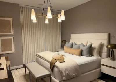 A bedroom with a bed, dresser, and a lamp.