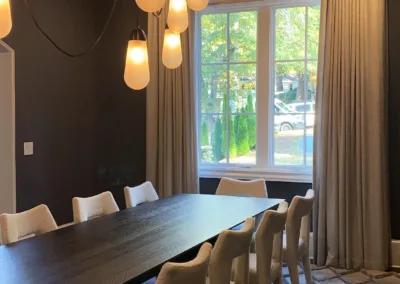 A dining room with a large table and chairs.
