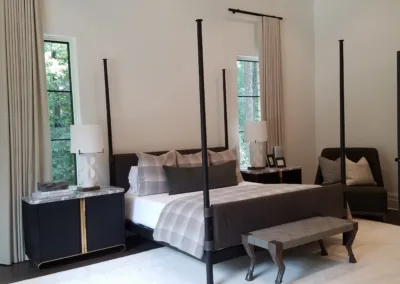 A bedroom with a four poster bed and a chair.