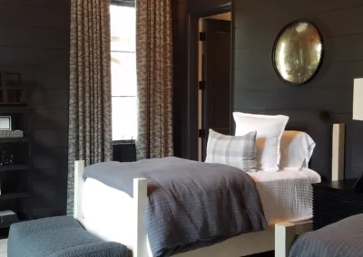 A bedroom with two beds and a chandelier.