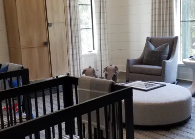 A baby's room with a crib and a chair.