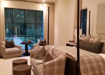 A bedroom with a large bed and a large window.