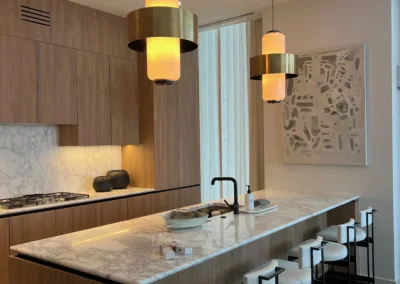 A modern kitchen with marble counter tops and wooden cabinets.
