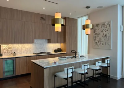 A modern kitchen with wooden cabinets and bar stools.