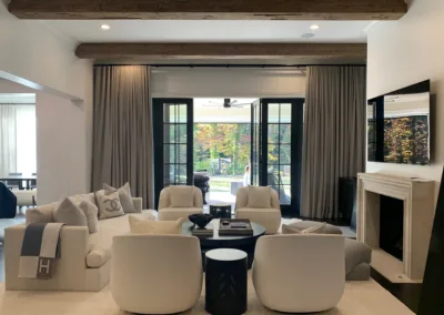 A living room with white furniture and a fireplace.